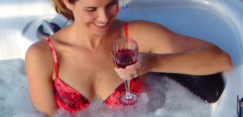 Woman relaxing and drinking a wine in a hot tub